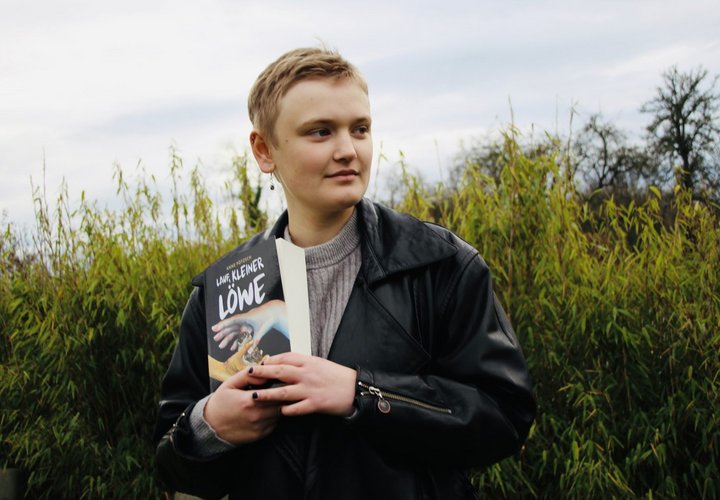 POrträt einer jungen Frau mit Buch in der Hand 