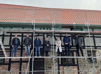 Auf dem Baugerüst an der Ackendorfer Museumsscheune feierten die Ackendorfer die fertigstellung des Daches.